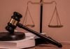 Número de processos contra operadores de apostas cresce mais de 600% em 2025 Uma mesa de tribunal com um malhete sobre um livro e a Balança da Justiça ao fundo