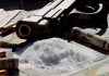 Arma, munições, drogas e dinheiro sobre uma mesa