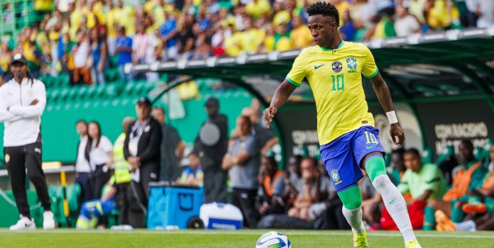 Vinícius Júnior carrega a bola durante partida da Seleção Brasileira.