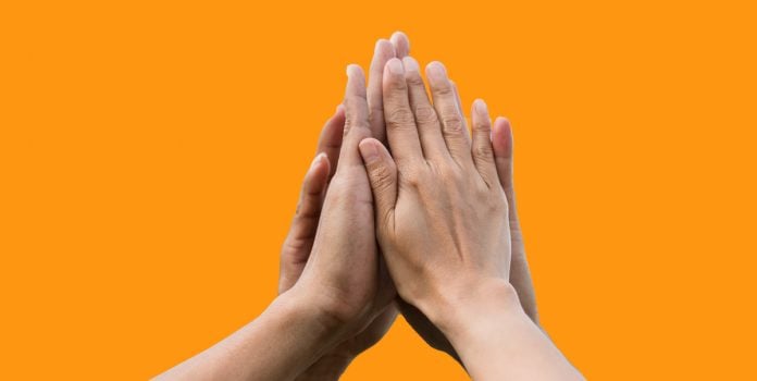 ABJR-e-APAJ-Firmam-Parceria-Para-Ampliar-Suporte-a-Apostadores Pessoas unindo as mãos, simbolizando parceria.