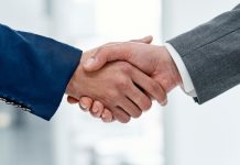 Betvip adota solução de apostas esportivas da FIRST.bet Duas pessoas apertando as mãos.