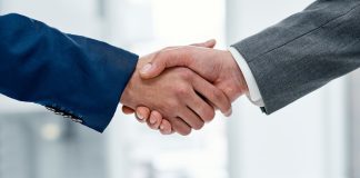 Betvip adota solução de apostas esportivas da FIRST.bet Duas pessoas apertando as mãos.