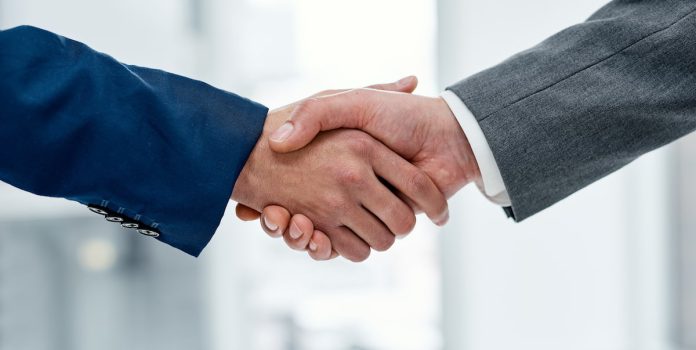 Betvip-Adota-Solucao-de-Sportsbook-da-FIRST-Bet Duas pessoas apertando as mãos.