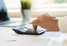 MPTCU pede investigação sobre impactos das apostas nas contas públicas Pessoa usando calculadora para fazer contas.