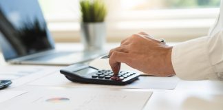 MPTCU pede investigação sobre impactos das apostas nas contas públicas Pessoa usando calculadora para fazer contas.