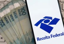 Receita Federal arrecada R$ 8,7 bilhões com apostas e jogos entre janeiro e julho de 2026 Notas de 100 reais ao lado de celular mostrando o aplicativo da Receita Federal.