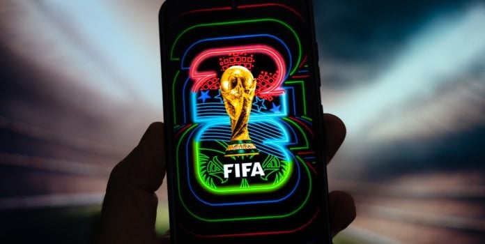 softswiss-analise-apostas-copa-do-mundo-2026 Símbolo da Copa do Mundo FIFA de 2026 exibido na tela de um celular