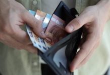 Homem retirando cédulas da carteira