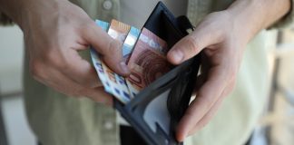 Apostas movimentam aproximadamente R$ 221 bilhões em 2025; divergências nos dados levantam alerta sobre mercado ilegal Homem retirando cédulas da carteira