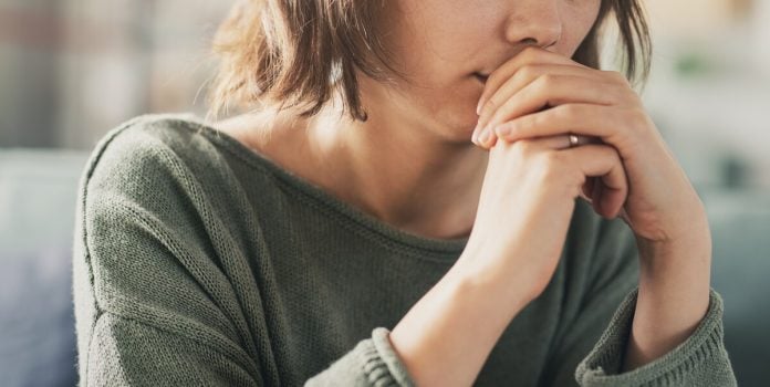 estudo-impactos-apostas-mulheres Mulher apreensiva com as mãos cobrindo a boca