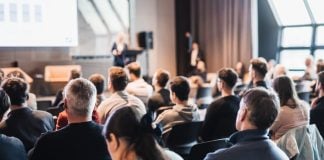 Casa JOTA promove debate sobre desafios do mercado ilegal; IBJR apoia iniciativa Pessoas em um auditório durante evento