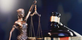 Estátua da justiça e martelo de tribunal.