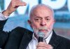 Lula gesticula com a mão direita enquanto segura um microfone com a mão esquerda durante comício eleitoral.