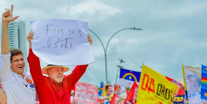 Lula-Proibe-Apostas-Online-no-Brasil O presidente Lula discursa em Recife e levanta um cartaz escrito "fim das bets".