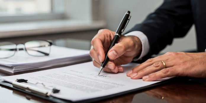 OKTO-PAYMENTS-Nomeia-Marcos-Techera-Como-Diretor-Geral-Para-America-Latina Foto de uma pessoa assinando um contrato.