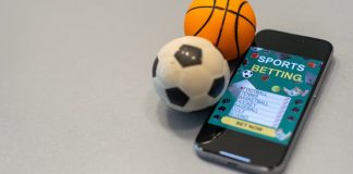 Rodrigo Capelo avalia que fim das casas de apostas ampliaria inadimplência de clubes Bola de futebol e de basquete ao lado de um celular com um aplicativo de apostas esportivas.