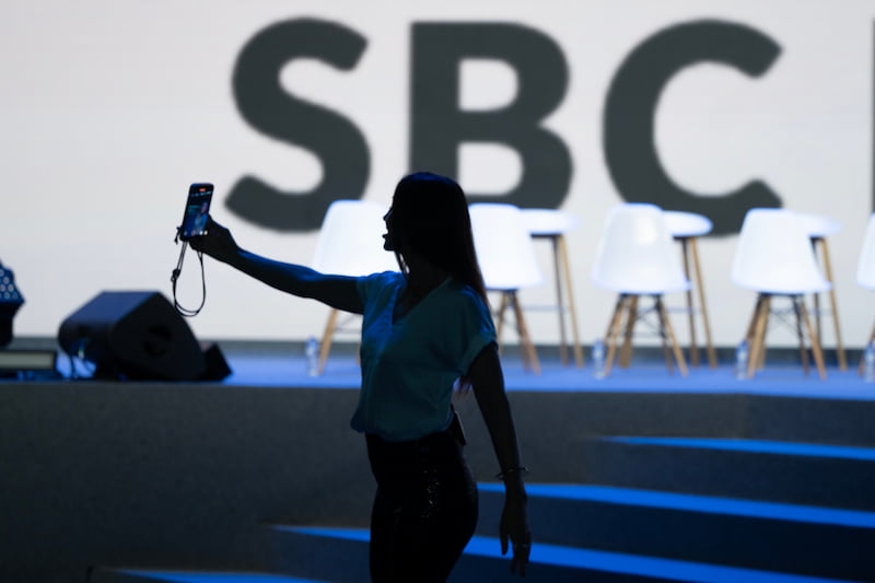 Mulher tira foto do SBC Summit 2025.