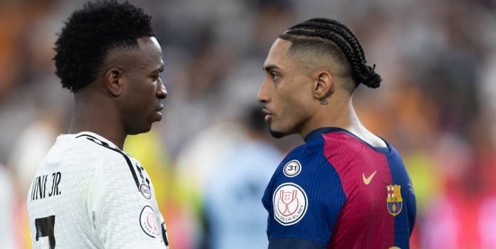SportyBet-Lanca-Campanha-Que-Levara-Fa-Brasileiro-Ao-El-Clasico-Na-Espanha Vinícius Júnior, astro do Real Madrid, cumprimenta Raphinha, estrela do Barcelona.