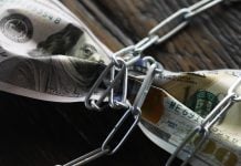 Governo regulamenta processo sobre valores bloqueados de empresas de apostas ilegais Uma nota de um dólar amarrada em uma corrente