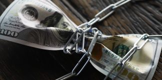 Governo regulamenta processo sobre valores bloqueados de empresas de apostas ilegais Uma nota de um dólar amarrada em uma corrente
