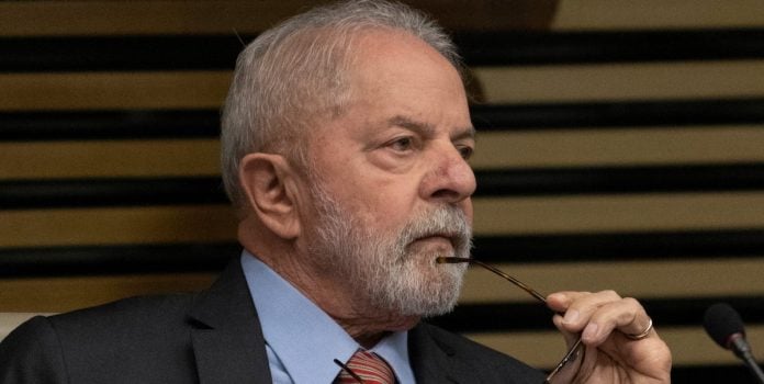 Lula é fotografado com o semblante pensativo, enquanto segura seu óculos.