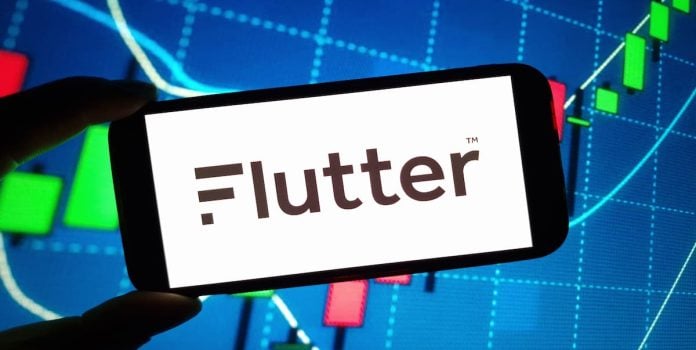 Flutter-Anuncia-Corte-de-Ate-1400-Empregos-Apos-Aumento-de-Impostos-no-Reino-Unido-1 Logotipo da empresa Flutter Entertainment exibido em um smartphone.