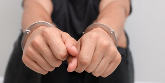Thiago-Iusim-Ontem-Consumidor-Hoje-Infrator-1 Homem tem mãos algemados com algemas de metais.