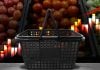 Cesta de compras em frete a frutas, com gráfico de crescimento no fundo