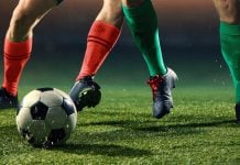 Duas pessoas jogando futebol em um campo