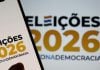 Celular exibindo "eleições de 2026" com destaque para a democracia